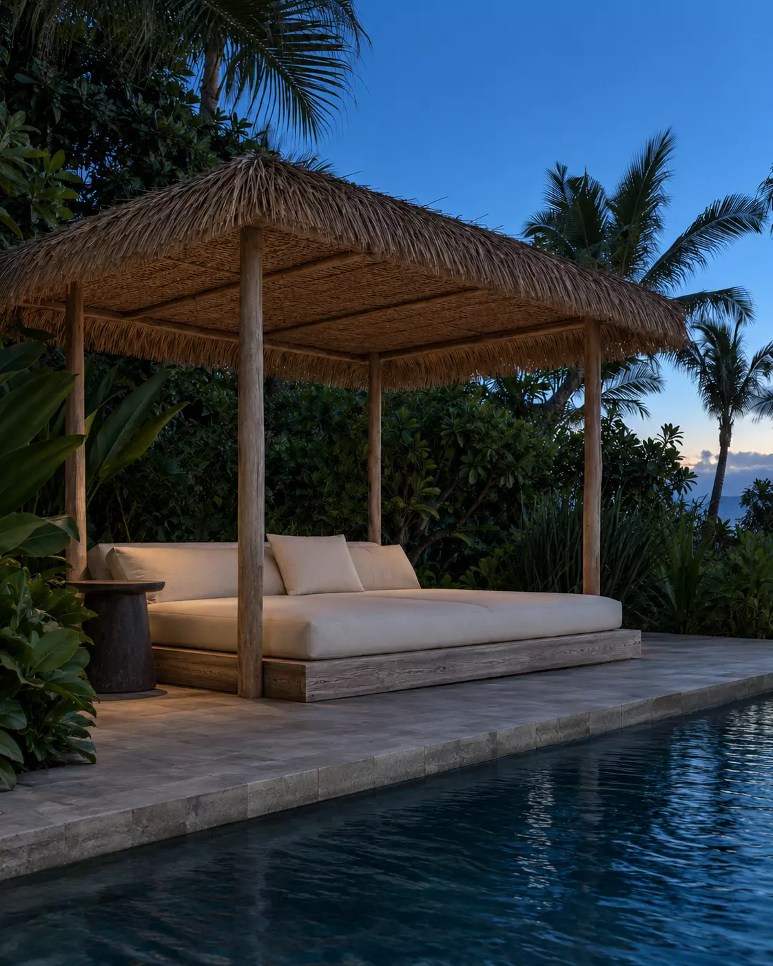 Cama exterior bajo techo de palma junto a una piscina, frente al mar.